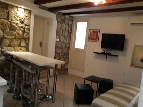a room with a table and a tv and a couch at House Nina in Dubrovnik