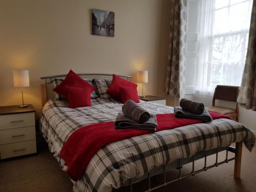 - une chambre avec un lit doté d'oreillers rouges dans l'établissement Charlotte Street 2 Bedroom Apartment, à Ayr