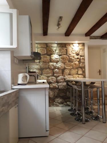 a kitchen with a stone wall and some bar stools at House Nina in Dubrovnik