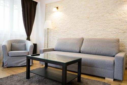 a living room with a couch and a table and a chair at Nest in Drobeta-Turnu Severin