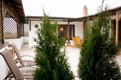 a patio with chairs and trees in front of a house at Nest in Drobeta-Turnu Severin