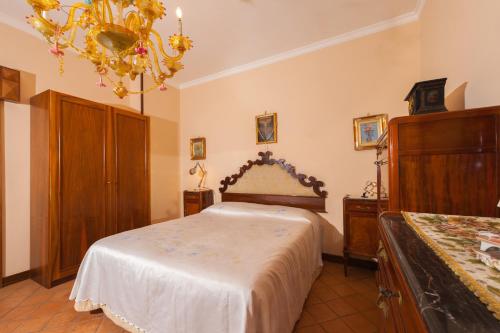 una camera con letto e lampadario a braccio di Holidays Naples Family - Pool in front of Capri a Napoli