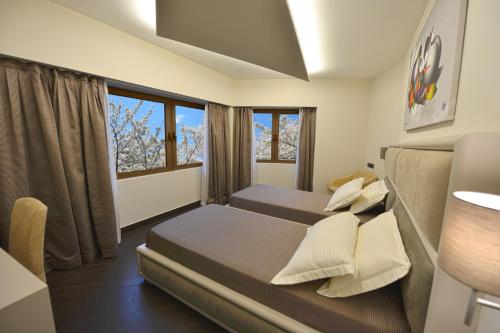 a bedroom with two beds and a window at Petit Hotel Elita in Shkodër