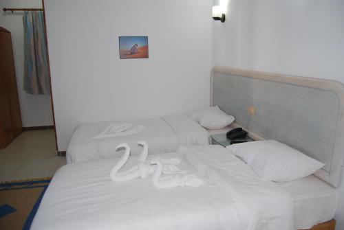 two beds in a room with white sheets and pillows at Acacia Dahab Hotel in Dahab