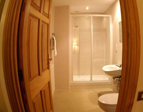 La salle de bains est pourvue d'une douche, de toilettes et d'un lavabo. dans l'établissement The George Inn & Millingbrook Lodge Ltd, à Lydney