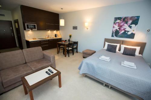 オストルダにあるWilla Port Apartament Liliaのベッドルーム1室(ベッド1台、ソファ付)、キッチン
