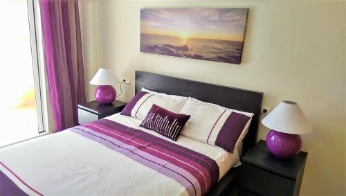 une chambre avec un lit avec deux lampes violettes dans l'établissement Golden Beach II, à Jávea
