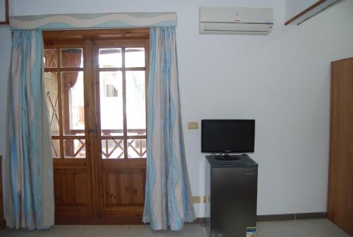 a room with a door with a television and a window at Acacia Dahab Hotel in Dahab