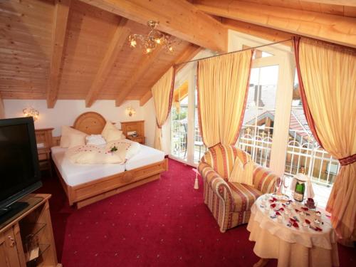 a bedroom with a bed and a tv in a room at Wellness & Landhotel Prinz- Wellness & Romantik in Anger