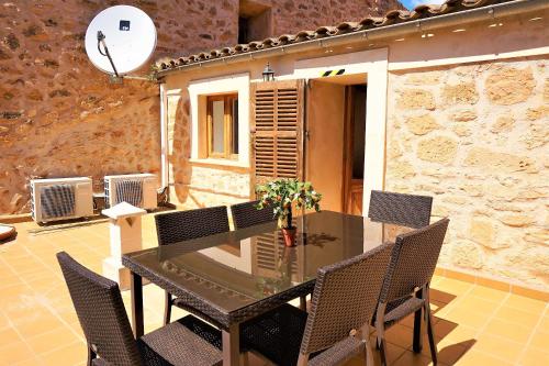 a patio with a table and chairs and a building at Ca'n Climent in Llucmajor