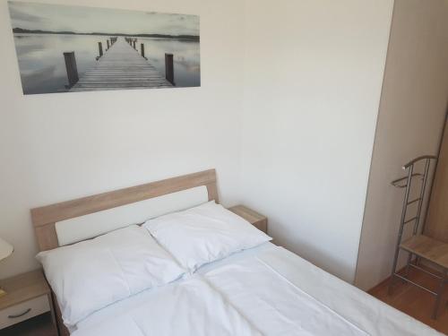 a bedroom with a bed with a picture of a pier at Schwalbennest in Ueckeritz
