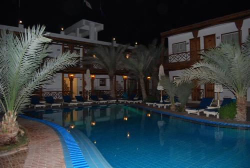 a swimming pool in front of a hotel at night at Acacia Dahab Hotel in Dahab