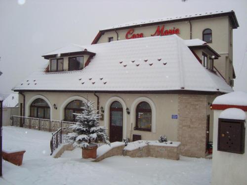 a building covered in snow with a sign on it at Casa Maria Arges in Piteşti