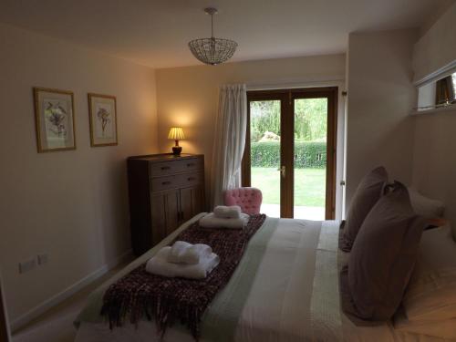 a bedroom with a bed with two towels on it at Willow Cottage in Bognor Regis