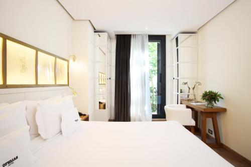 a bedroom with a large white bed and a desk at Ofelias Hotel 4Sup by Bondia Hotel Group in Barcelona