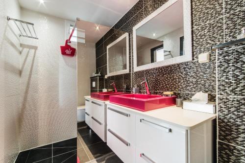 y baño con ducha y 2 lavabos rojos. en JoliReveCreole, en Sainte-Anne