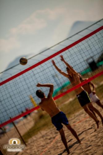 two men playing a game of volleyball on a beach at Albergo Diffuso Mannois in Orosei