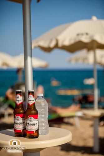three bottles of beer sitting on a table at the beach at Albergo Diffuso Mannois in Orosei