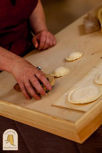 a person is preparing food on a cutting board at Albergo Diffuso Mannois in Orosei