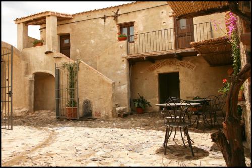 an old house with a table and chairs in a courtyard at Albergo Diffuso Mannois in Orosei
