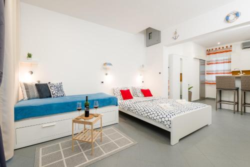 een witte kamer met 2 bedden en een tafel bij Studio apartment Sesula in Split