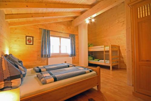 ein Schlafzimmer mit einem Bett in einem Blockhaus in der Unterkunft Almliesl GAST-481 in Bad Gastein