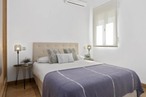 - une chambre blanche avec un grand lit et une fenêtre dans l'établissement Gran Vía, à Madrid