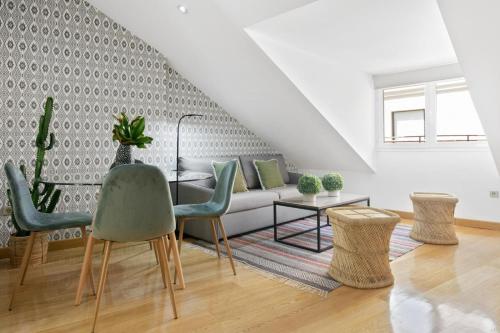 een woonkamer met een bank, een tafel en stoelen bij Gran Vía - Tu Apartamento Ideal para Disfrutar Madrid al Máximo in Madrid
