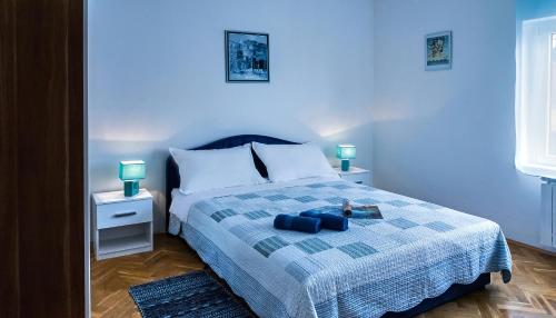 a bedroom with a bed with two blue pillows at Apartmani AMI in Podstrana