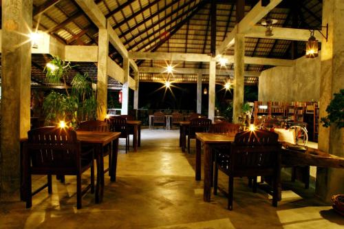a restaurant with wooden tables and chairs and lights at Tropicana Lanta Resort in Ko Lanta