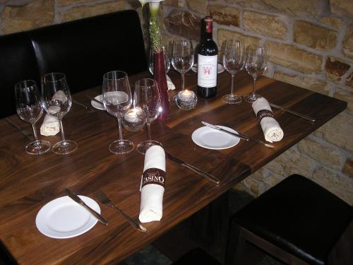 a wooden table with wine glasses and wine bottles at AKZENT Hotel Altes Casino in Fulda