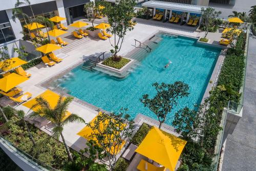 
a beach with a pool, chairs, tables and umbrellas at Shangri-La Colombo in Colombo
