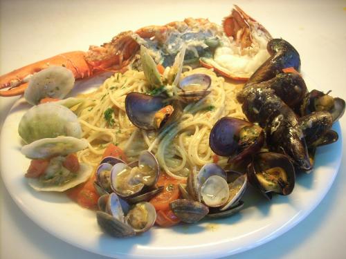 a plate of pasta with mussels and seafood on it at Ai Campi Di Marcello Hotel in Monfalcone