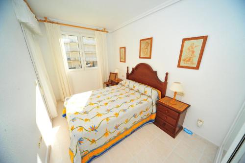 a bedroom with a bed and a table and a window at Cala Gonzalez Superior Orange Costa in Alcossebre