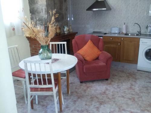 a kitchen with a table and a couch and a chair at Casa Rural de la Parra in La Adrada