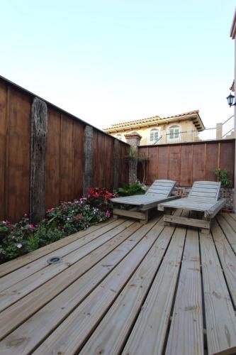 a wooden deck with two benches and a fence at My Chateau Resort in Kenting