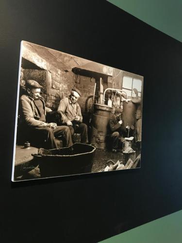 a black and white photo of three men in a kitchen at Chez Jeanmyvonne in La Bresse