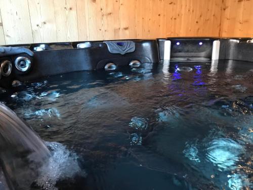 a hot tub filled with water in a room at Chez Jeanmyvonne in La Bresse
