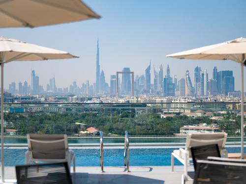a view of a city skyline with chairs and umbrellas at Al Bandar Arjaan by Rotana – Dubai Creek in Dubai