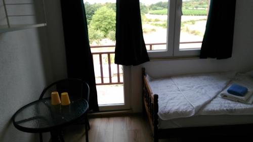 a bedroom with a bed and a table and a window at Pansion Ivanka Barac in Međugorje