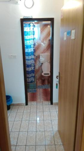 a bathroom with a toilet and a door to a room at Pansion Ivanka Barac in Međugorje