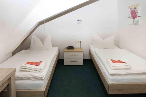 two twin beds in a room with a green carpet at Schlossgasthaus Lichtenwalde in Lichtenwalde