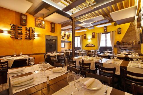a restaurant with tables and chairs with white tablecloths at Alhambra Suites in Madrid