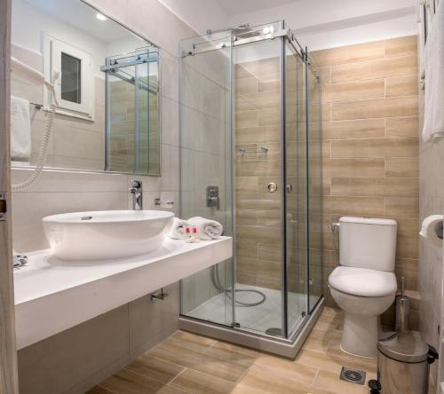 a bathroom with a shower and a sink and a toilet at Hotel Strass in Paralia Katerinis