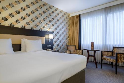 a hotel room with a bed and a desk at Mercure Antwerp City South in Antwerp