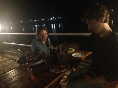 a man and a woman sitting at a table with food at Carambola Bungalow in Phong Nha