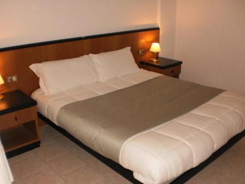 a large bed in a room with two night stands at RTA Le Corti in Grosseto