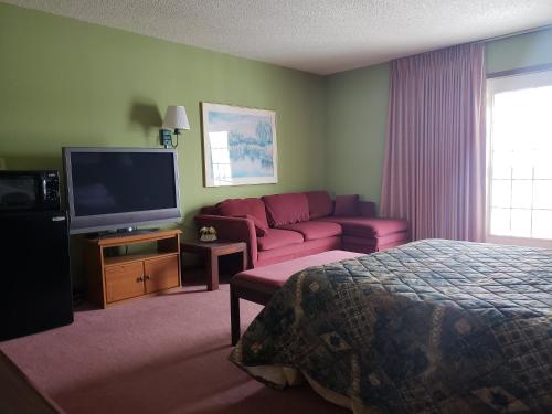 a hotel room with a couch and a television at Harbor Lights Lodge in Kewaunee