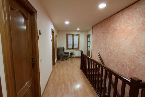 a hallway with a staircase and a chair in a house at El Pedrís in El Pont de Suert