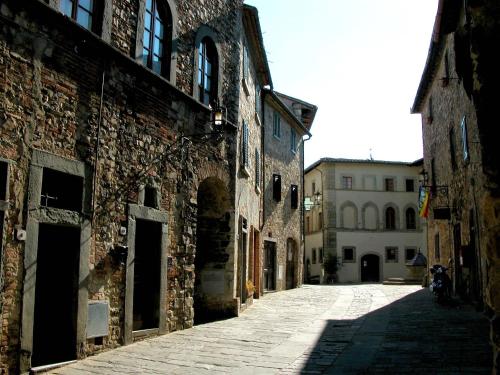 an alley in an old building with a motorcycle parked on it at Le Terrazze Del Chianti b&b Residenza d'Epoca e di Charme in Tavarnelle in Val di Pesa